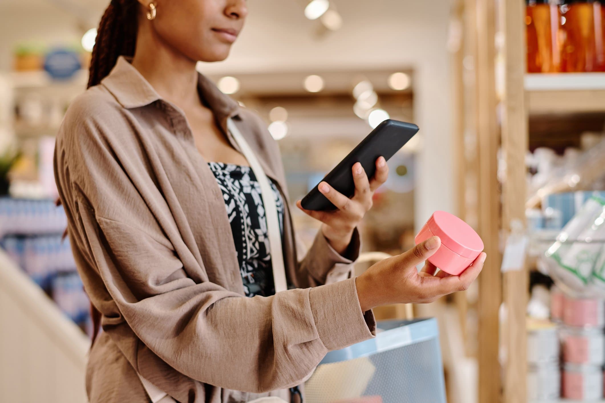A photo of someone shopping for makeup and skincare in a store using their phone.